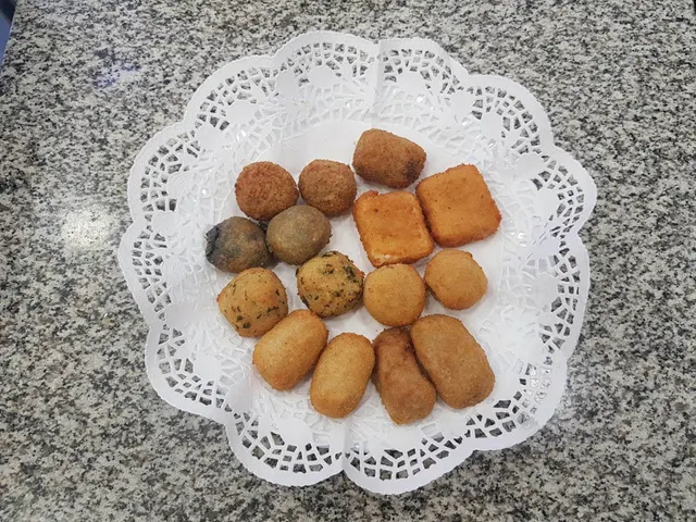 Croquetas variadas sobre una blonda de papel
