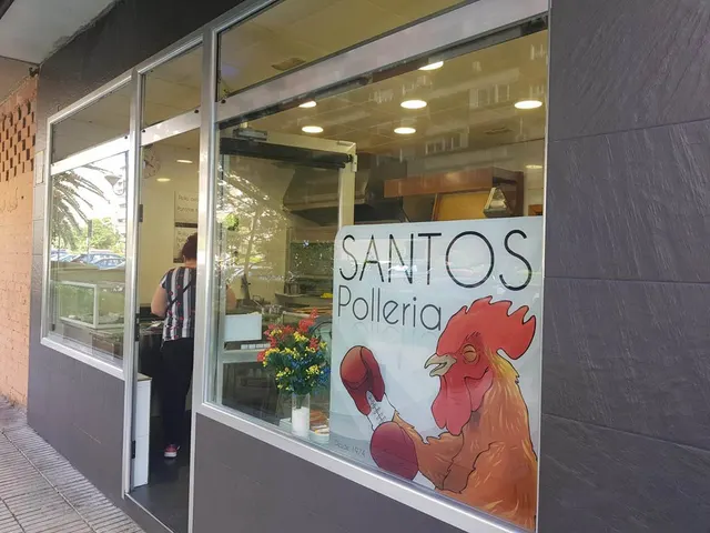 Fachada de la pollería, con el rótulo del gallo en el escaparate